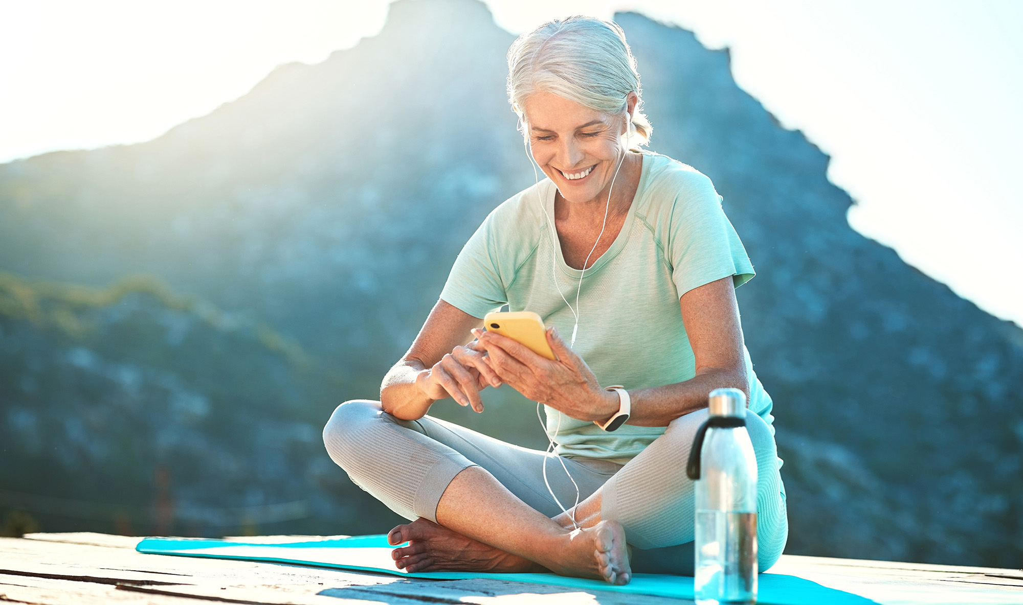 woman seated in yoga pose on smart phone