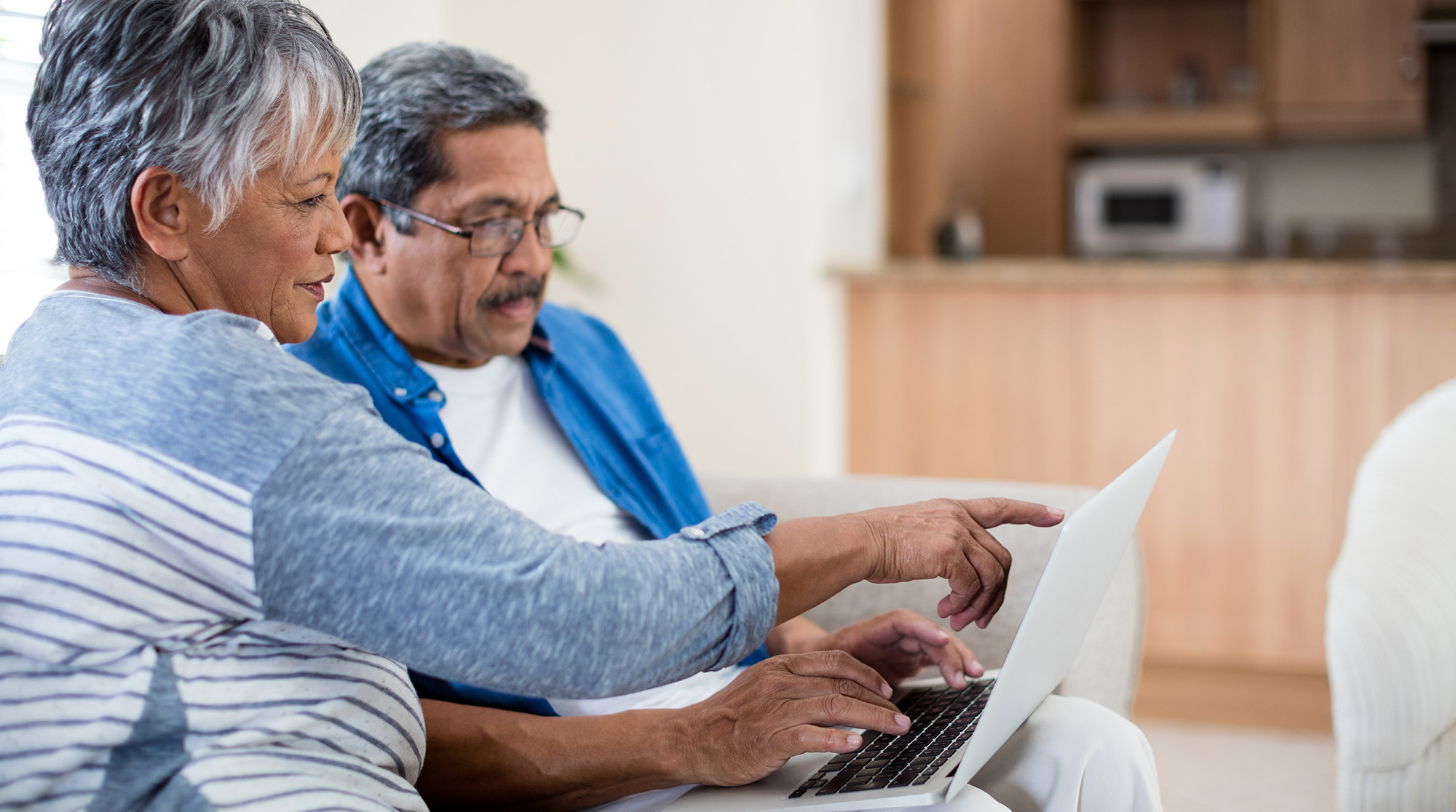 senior couple looking at computer laptop